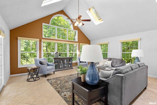 tiled living room with ceiling fan, a skylight, and plenty of natural light