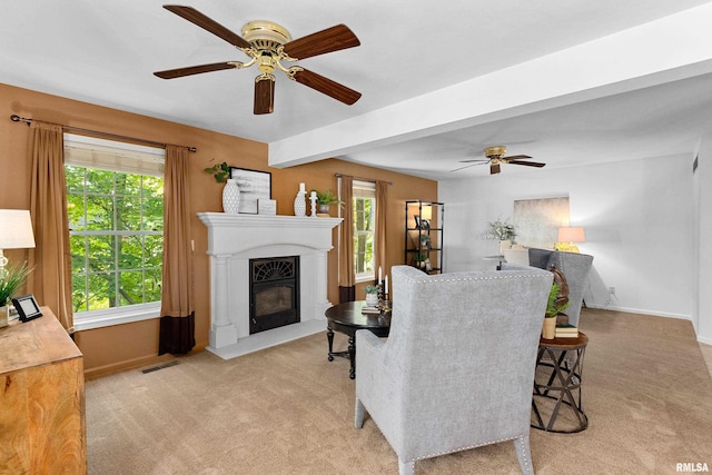 living room featuring light colored carpet, ceiling fan, and beamed ceiling