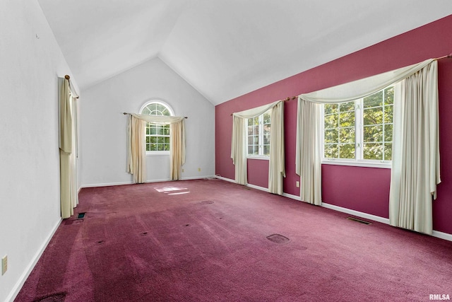 carpeted spare room featuring vaulted ceiling and a healthy amount of sunlight