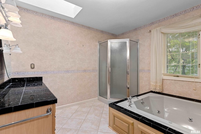 bathroom with independent shower and bath, vanity, a skylight, and tile patterned floors