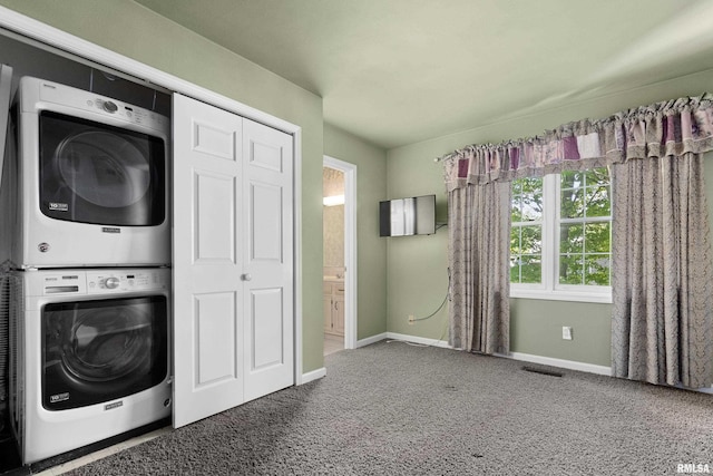 clothes washing area with carpet floors and stacked washer and clothes dryer