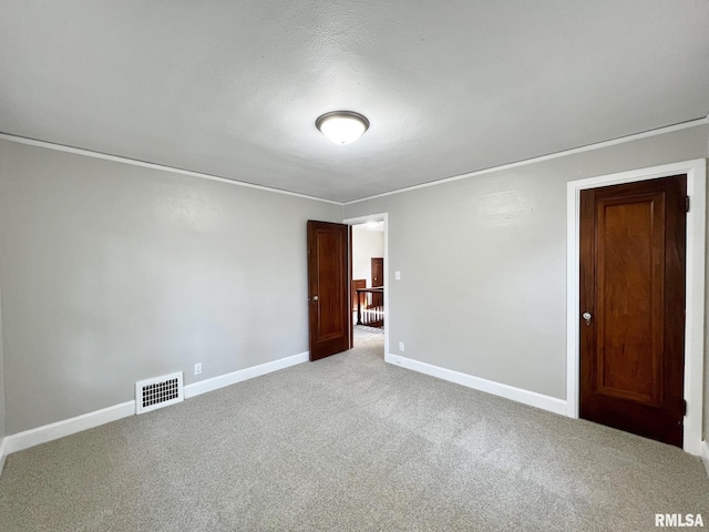 carpeted empty room with a textured ceiling