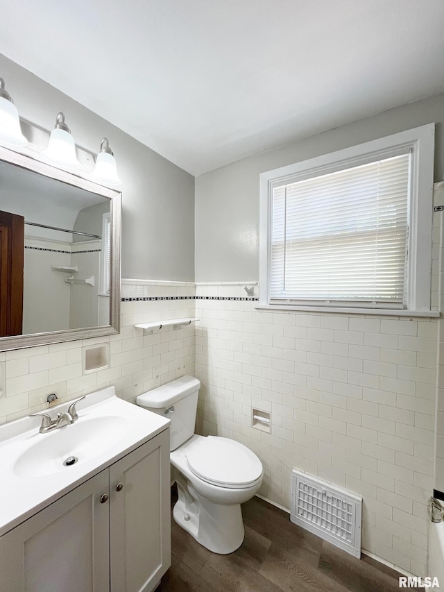 bathroom with tile walls, vanity, toilet, and hardwood / wood-style flooring