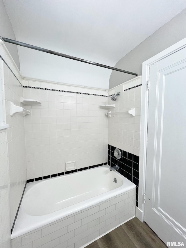 bathroom featuring wood-type flooring and tiled shower / bath combo