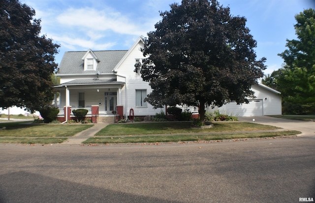 view of front of property featuring covered porch, a front yard, and a garage