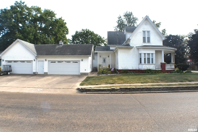 view of front facade featuring a garage, a porch, and a front lawn