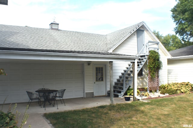 back of property featuring a yard and a garage