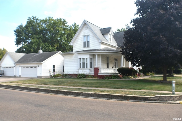 country-style home with covered porch, a front yard, and a garage