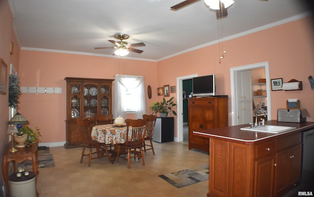 kitchen featuring ceiling fan, ornamental molding, a kitchen island with sink, and sink