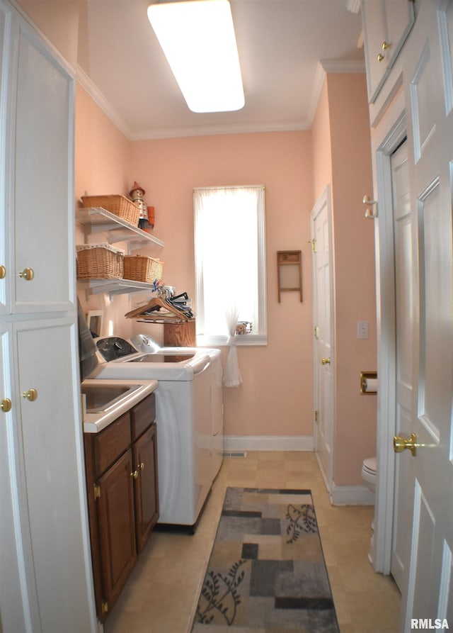 laundry area with separate washer and dryer, ornamental molding, and light tile patterned floors