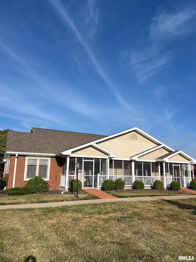 ranch-style house with a sunroom and a front lawn