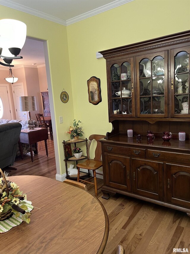 dining area with crown molding and wood-type flooring