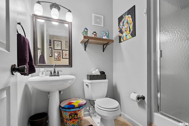 bathroom featuring tile patterned floors, toilet, and walk in shower