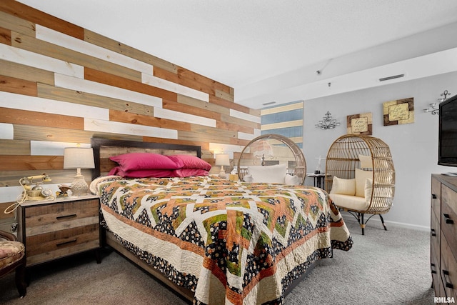 carpeted bedroom featuring wood walls