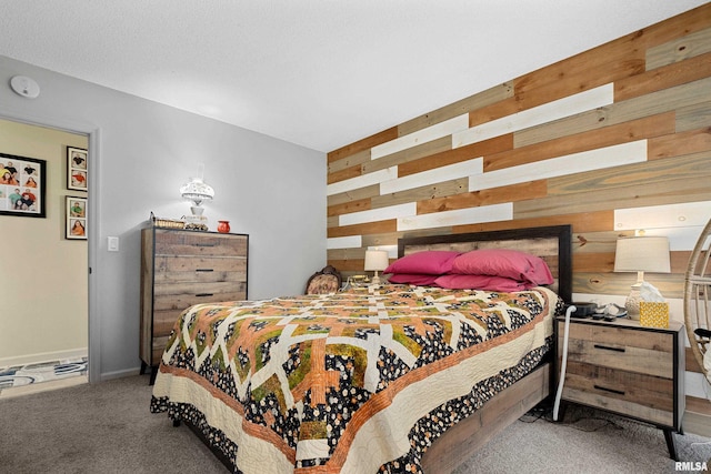 bedroom with carpet floors and wooden walls