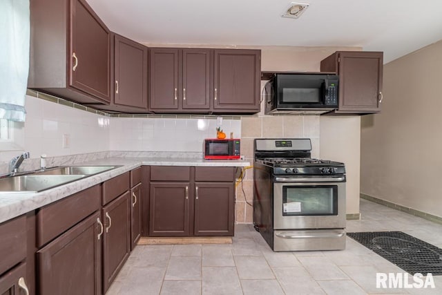 kitchen with decorative backsplash, light tile patterned floors, sink, and stainless steel gas range