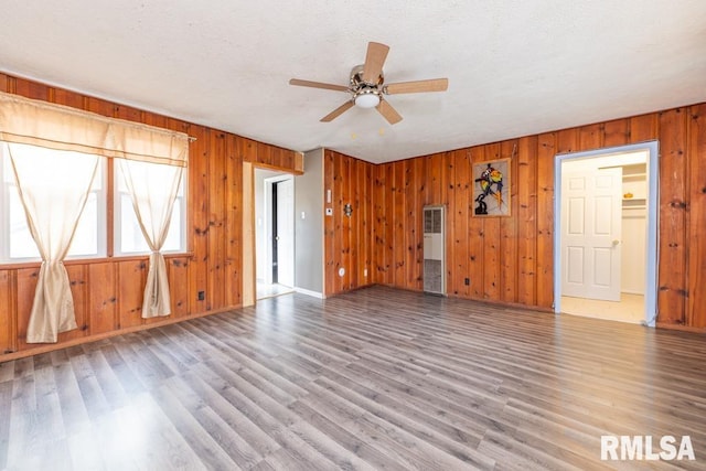 unfurnished living room featuring wooden walls and hardwood / wood-style floors