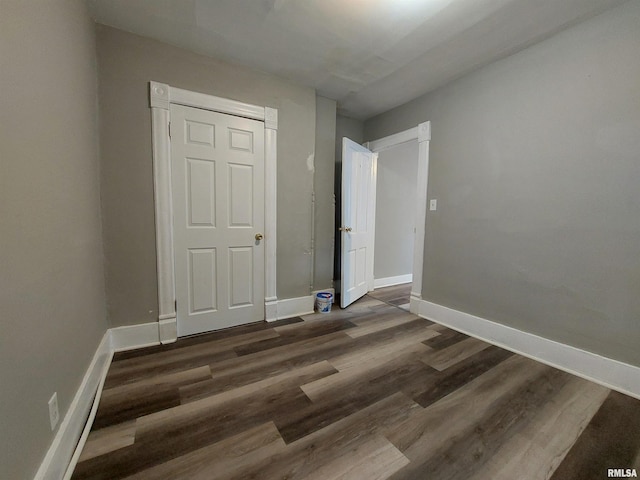 unfurnished bedroom with dark hardwood / wood-style flooring