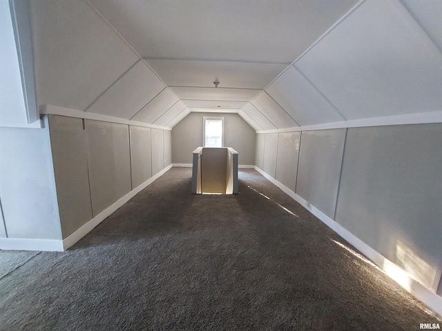 bonus room featuring vaulted ceiling and dark carpet