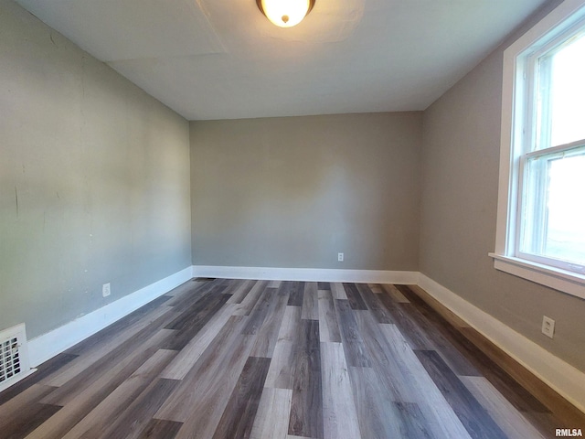 empty room with dark hardwood / wood-style flooring