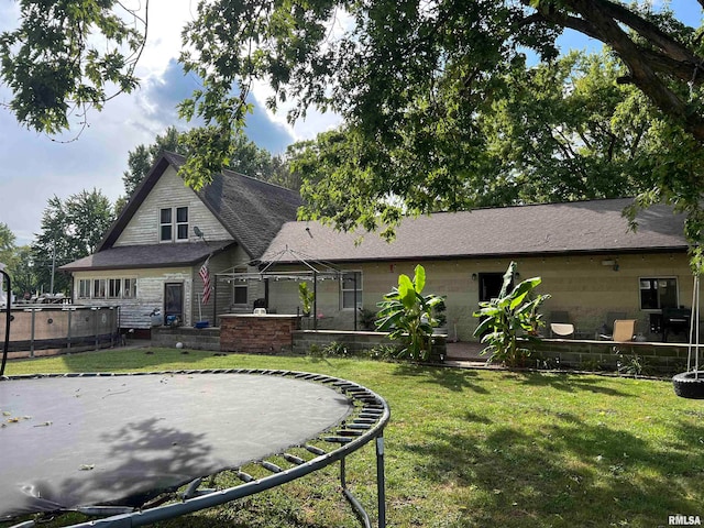 rear view of property featuring a lawn and a patio