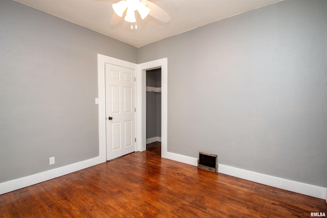 spare room with dark hardwood / wood-style flooring and ceiling fan