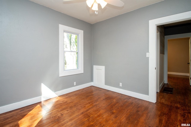 empty room with dark hardwood / wood-style flooring and ceiling fan