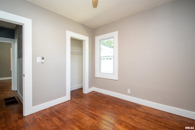 unfurnished bedroom with a closet, ceiling fan, and dark wood-type flooring