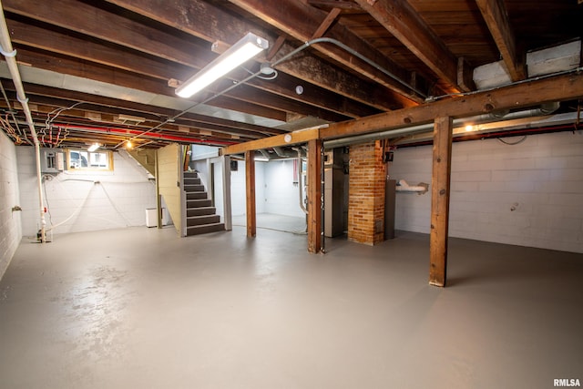 basement featuring electric panel and heating unit