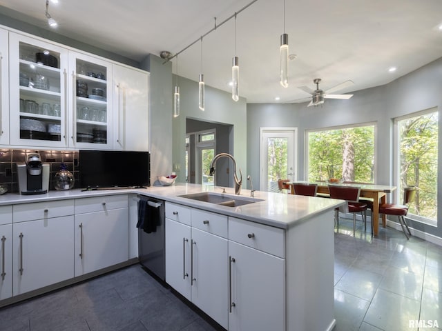 kitchen with white cabinets, stainless steel dishwasher, hanging light fixtures, and sink