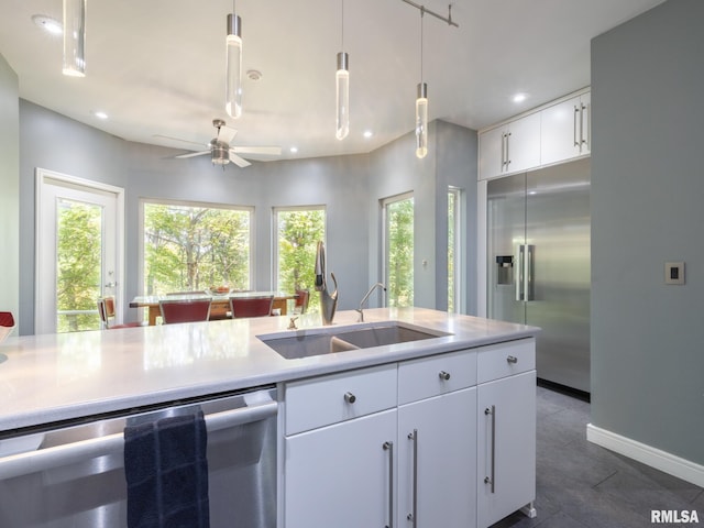 kitchen featuring pendant lighting, white cabinetry, appliances with stainless steel finishes, ceiling fan, and sink