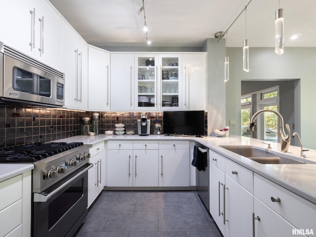 kitchen with sink, stainless steel appliances, pendant lighting, and white cabinetry