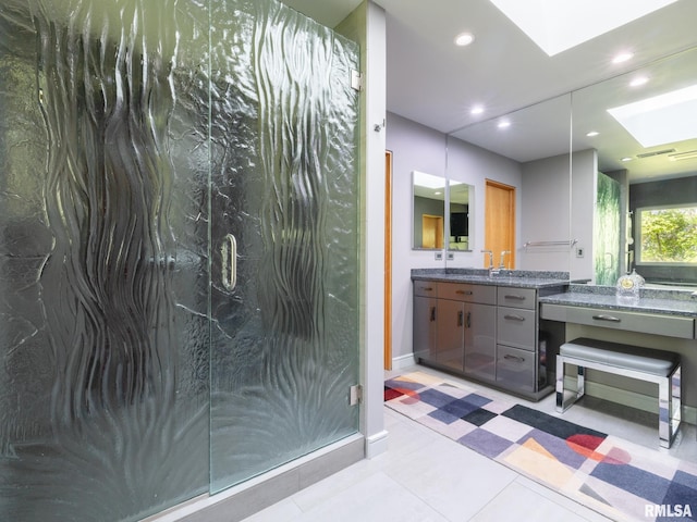 bathroom with an enclosed shower, vanity, tile patterned flooring, and a skylight