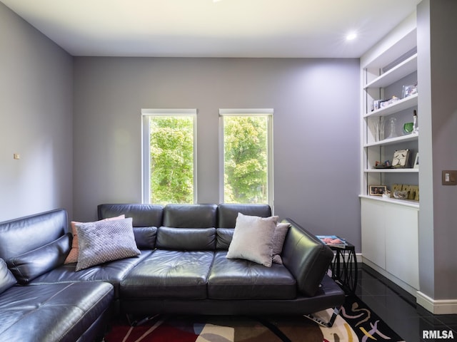 living room featuring built in shelves and dark tile patterned flooring