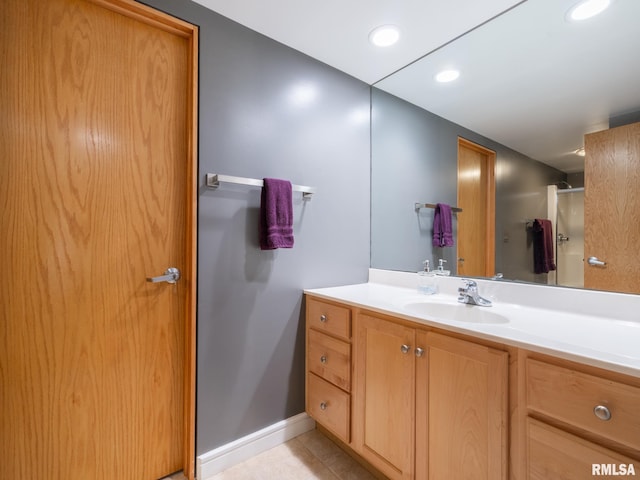 bathroom with a shower, vanity, and tile patterned floors