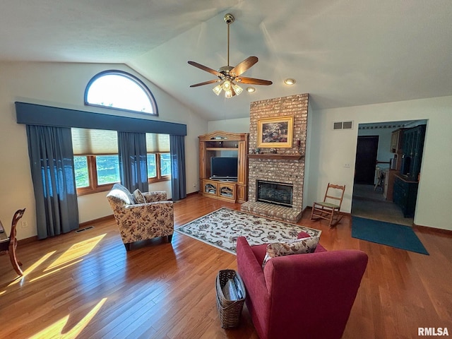 living room featuring a brick fireplace, vaulted ceiling, ceiling fan, and hardwood / wood-style flooring