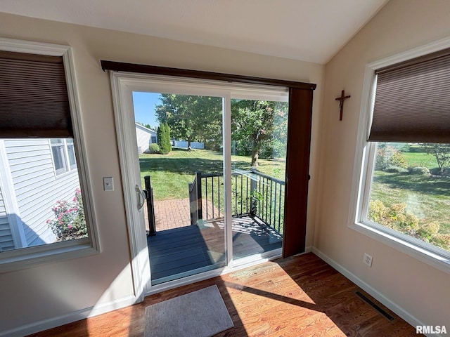 doorway to outside with lofted ceiling and dark hardwood / wood-style flooring