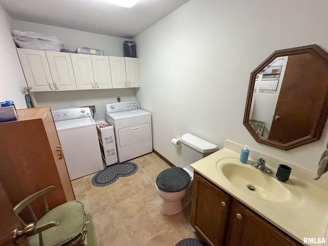 bathroom featuring toilet, sink, and washing machine and dryer