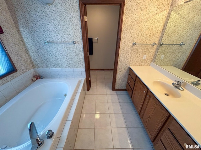 bathroom with a relaxing tiled tub, vanity, and tile patterned flooring