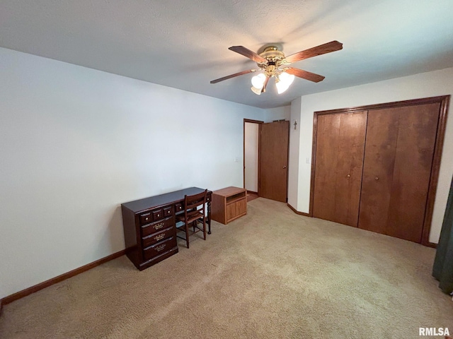 unfurnished bedroom featuring light carpet, ceiling fan, and a closet