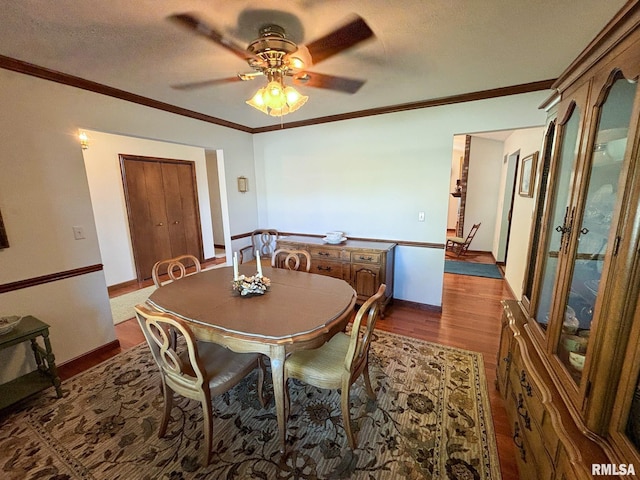 dining room featuring crown molding, dark hardwood / wood-style flooring, and ceiling fan