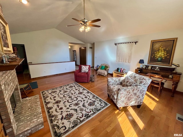 living room featuring ceiling fan, hardwood / wood-style flooring, a fireplace, and lofted ceiling