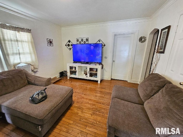 living room with hardwood / wood-style flooring and crown molding