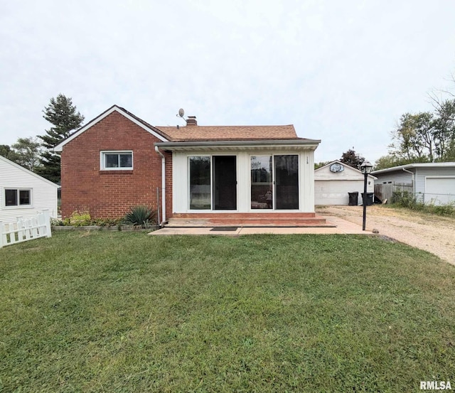 back of property featuring a garage, a patio area, and a yard