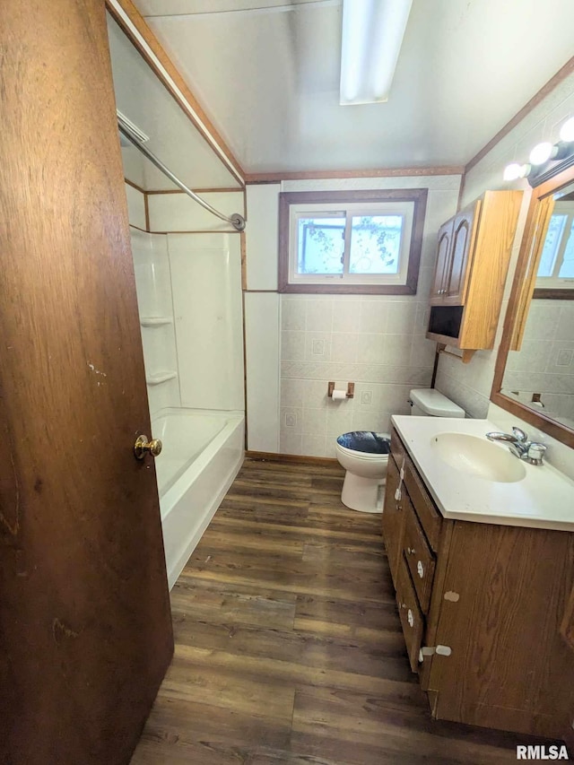 full bathroom featuring vanity, wood-type flooring, shower / tub combination, tile walls, and toilet