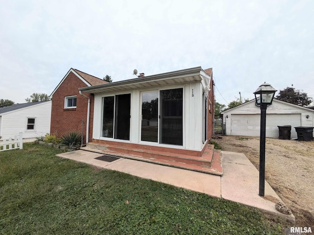 back of house featuring a yard, an outbuilding, and a garage