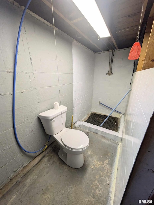 bathroom with walk in shower, toilet, and concrete flooring