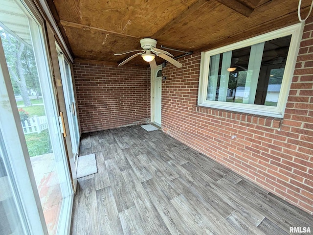 unfurnished sunroom with ceiling fan and wooden ceiling