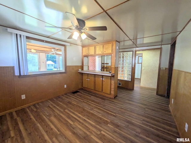 kitchen featuring kitchen peninsula, wood walls, dark hardwood / wood-style flooring, and ceiling fan