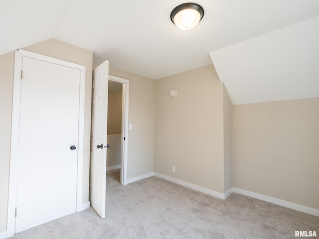 bonus room with light carpet and vaulted ceiling